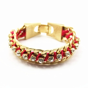 Vue macro détaillée du bracelet chaîne en alliage doré avec corde rouge et cristaux brillants