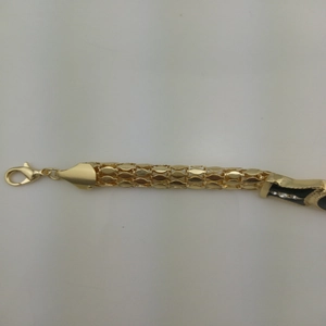 Detail of snake chain bracelet with lion head motif, black enamel, and white crystals
