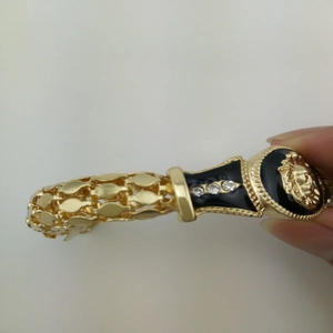 Gold hollow mesh bracelet featuring a black enamel lion head charm with rhinestone accents