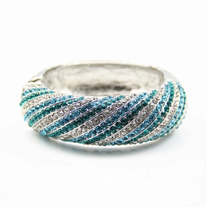 Close-up of chunky silver alloy bangle with blue and white rhinestone diagonal pattern
