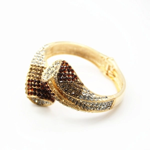 Détail d'un bracelet doré orné de strass dégradés champagne et blancs scintillants