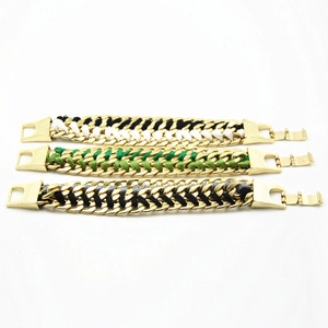 Close-up of woven alloy chain bracelets with colorful cotton cord detail in gold finish