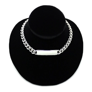 Chunky alloy curb chain necklace with a rectangular metal plaque on a black display stand