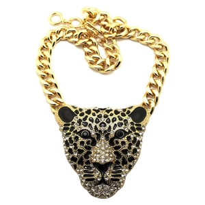 Macro shot of gold-plated leopard head pendant with crystal accents and thick cuban chain