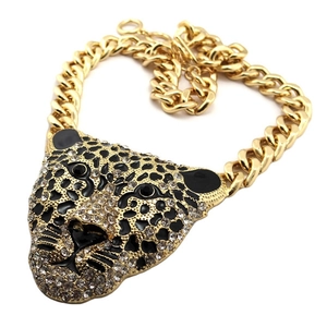 Chunky gold panther head necklace with crystals and black enamel on a flat white background