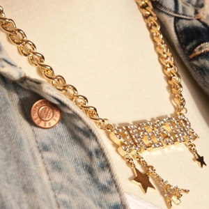 Close-up of gold chunky chain necklace with FRESH rhinestone pendant and charms
