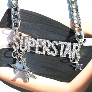 Close-up of silver chunky chain necklace with rhinestone superstar pendant and star charms