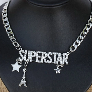 Detailed view of silver Superstar necklace with Eiffel Tower and star charms on neck bust