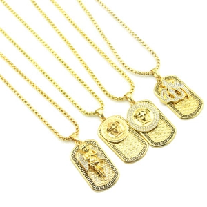 Detailed macro view of four gold rectangular pendant necklaces with varied hip-hop engravings