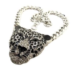 Close-up of a leopard-shaped sweater necklace with sparkling rhinestones and a curb chain