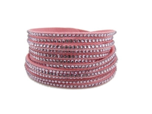 Détail du bracelet multicouche en velours rose orné de rangées de strass brillants