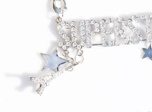 Detail of silver alloy necklace featuring rhinestone superstar letters and star charms
