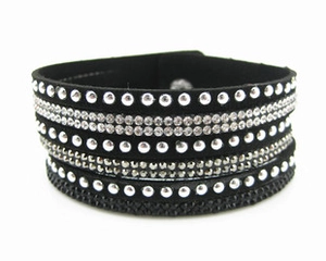 Détail d'un bracelet multi-rangs noir avec des clous argentés et des strass étincelants
