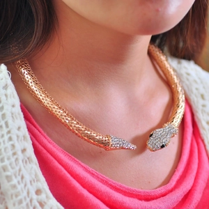 Vue détaillée d'un collier ras du cou serpent doré avec strass brillants sur le cou