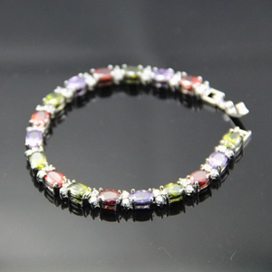 Detailed macro view of silver bracelet featuring multi-color oval cut zircon gemstones