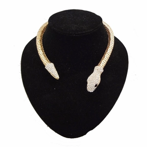 Gros plan d'un collier ras du cou serpent doré avec strass brillants sur buste noir