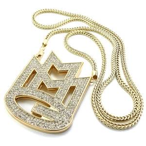 Macro view of iced-out gold crown pendant with micro-pave crystals on thick woven chain
