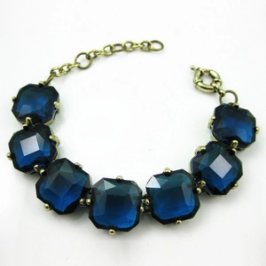 Close-up of vintage bronze bracelet featuring square blue crystal gemstones with clasp