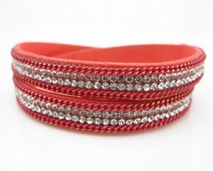 Bracelet enveloppant en velours rouge avec strass brillants et chaîne en métal sur blanc