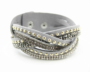 Detail van grijze suède wikkelarmband met fonkelende strass en metalen studs