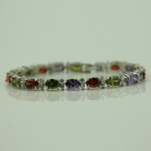 Detail shot of multicolor oval-cut gemstones and small diamonds on a silver tennis bracelet