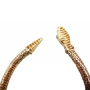 Gros plan détaillé du bracelet serpent doré avec texture d'écailles et tête en maille