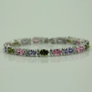 Detailed macro view of silver tennis bracelet with colorful oval zirconia and white stones