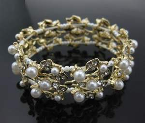 Detail of vintage gold alloy bracelet with white pearls and sparkling rhinestones
