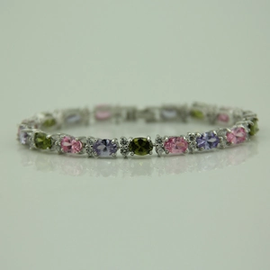Macro view of a luxury silver bracelet featuring oval-cut colorful zircon gemstones and crystals