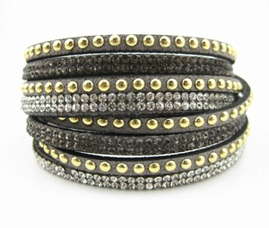 Dettaglio del bracciale avvolgente boho in pelle scamosciata grigia con borchie e cristalli