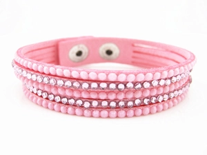 Detail of pink multilayer velvet bracelet featuring rows of rhinestones and metal snaps