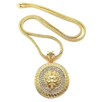 Close-up of gold lion head pendant with rhinestone inlay and Greek key pattern