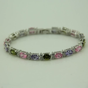 Detail of colorful oval-cut crystals in pink, purple and green on a silver metal bracelet