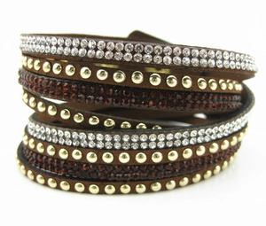 Dettaglio del bracciale multistrato in velluto marrone con strass e borchie dorate