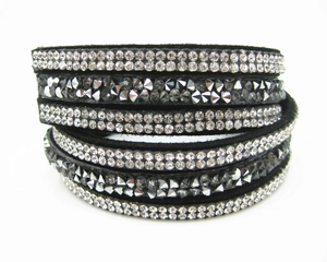 Macro detail of multi-layer wrap bracelet featuring black velvet and rows of sparkling crystals