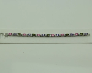 Close-up of multicolor oval gemstone tennis bracelet with silver claw setting and small zircons