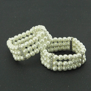 Elegant multi-layer pearl bracelet set with silver rhinestone dividers on grey surface