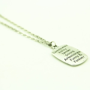 Dettaglio del ciondolo in argento con le parole Complicated, Strong e Forever incise