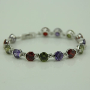Detail of silver bracelet featuring round cut purple, red and green gemstone insets