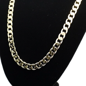 Close-up of 12mm wide gold Cuban link chain necklace on black velvet jewelry display