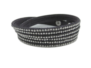 Détail d'un bracelet enveloppant multicouche en daim gris foncé avec des strass brillants