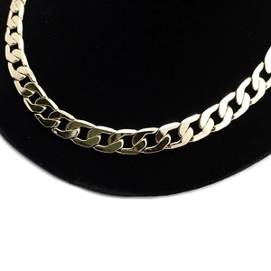 Detail of 12mm wide gold-colored curb chain necklace links with a high-polished finish