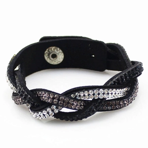Détail d'un bracelet tressé en velours noir orné de strass brillants blancs et noirs