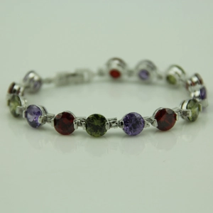 Detailed view of round cut multi-color gemstones in silver prong settings for bracelet