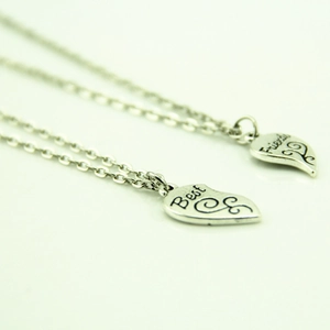 Détail des pendentifs cœur argentés gravés Best Friends sur des chaînes assorties