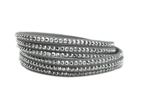 Détail macro du bracelet multicouche en daim gris orné de rangées de strass brillants