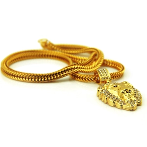Détail macro du pendentif tête de lion doré serti de strass sur chaîne serpent
