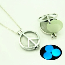 Detailed view of hollow peace symbol locket with blue glowing bead and silver finish