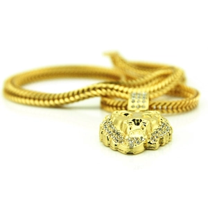 Vue détaillée du pendentif tête de lion doré avec strass brillants et chaîne serpent