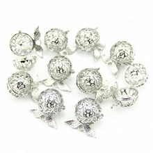 Macro detail of silver hollow flower cage pendants with leaf accents for DIY jewelry
